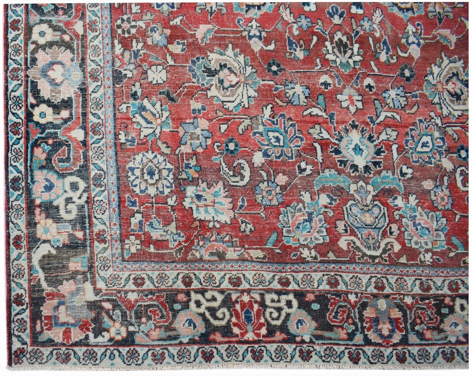 A vintage handwoven Persian Tabriz rug featuring intricate floral patterns in red and blue tones.