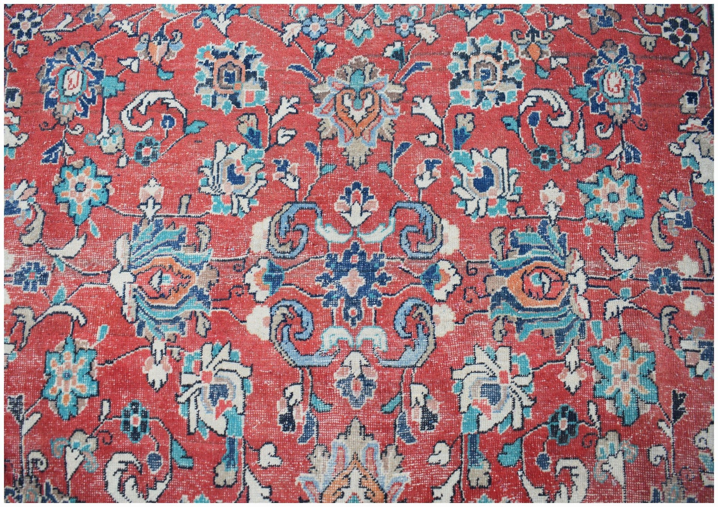 A vintage Persian Tabriz rug featuring intricate floral patterns in red, blue, and cream tones.
