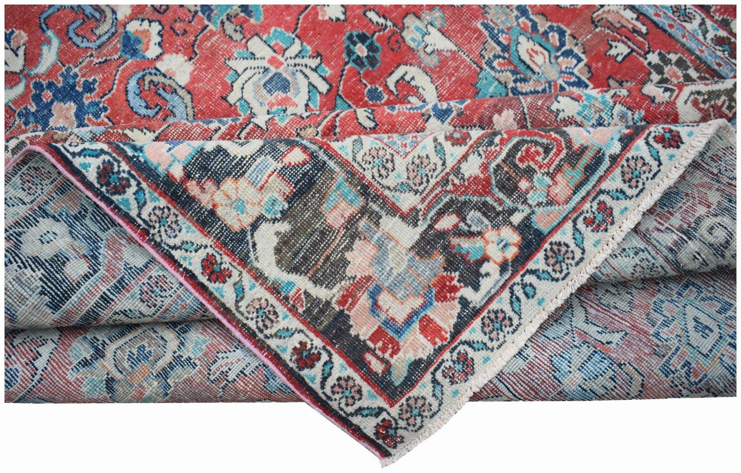 A vintage handwoven Persian Tabriz rug featuring intricate floral patterns in red and blue tones.