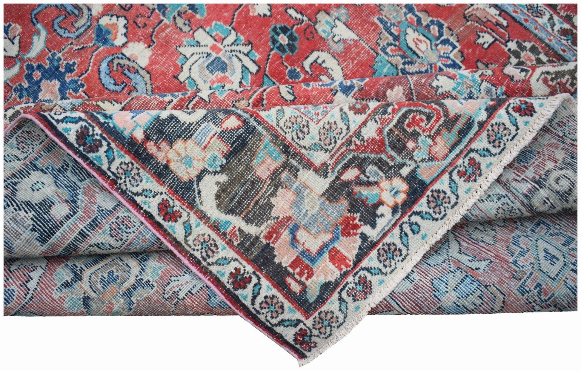 A vintage handwoven Persian Tabriz rug featuring intricate floral patterns in red and blue tones.
