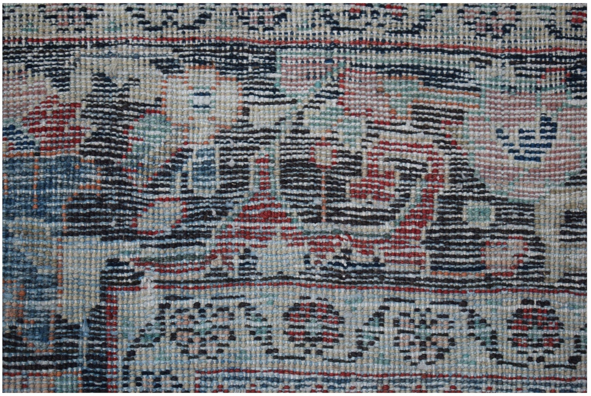 A close-up view of a vintage Persian Tabriz rug featuring intricate floral patterns and wool pile.