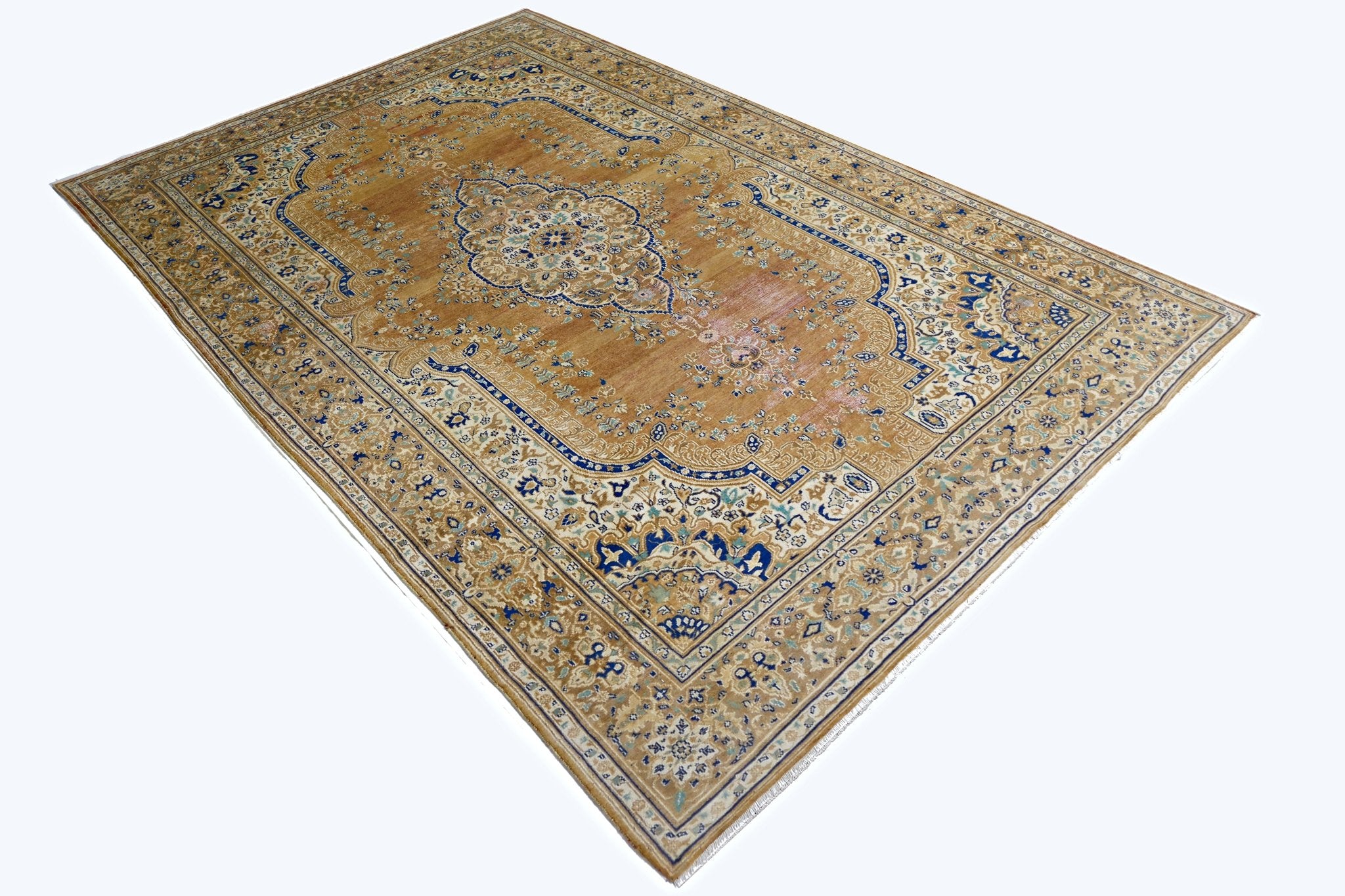 A vintage Persian Tabriz rug featuring a central medallion on a golden field with blue accents.