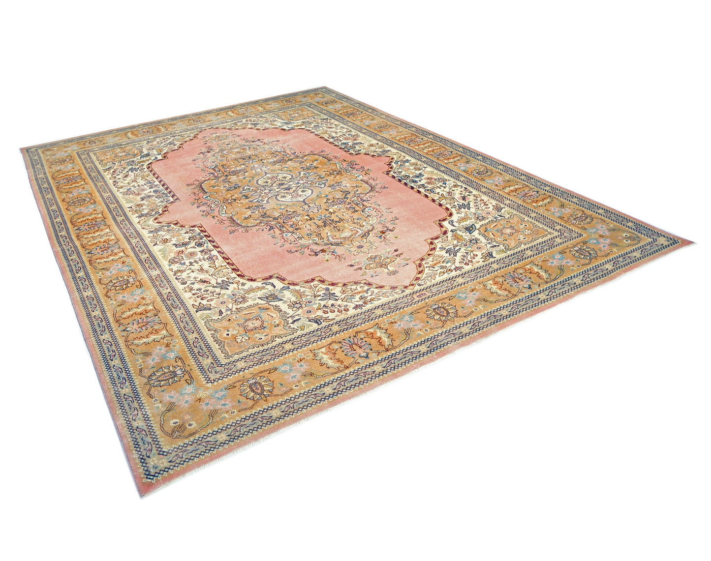 A vintage Persian Tabriz rug featuring a central floral medallion on a soft pink field.