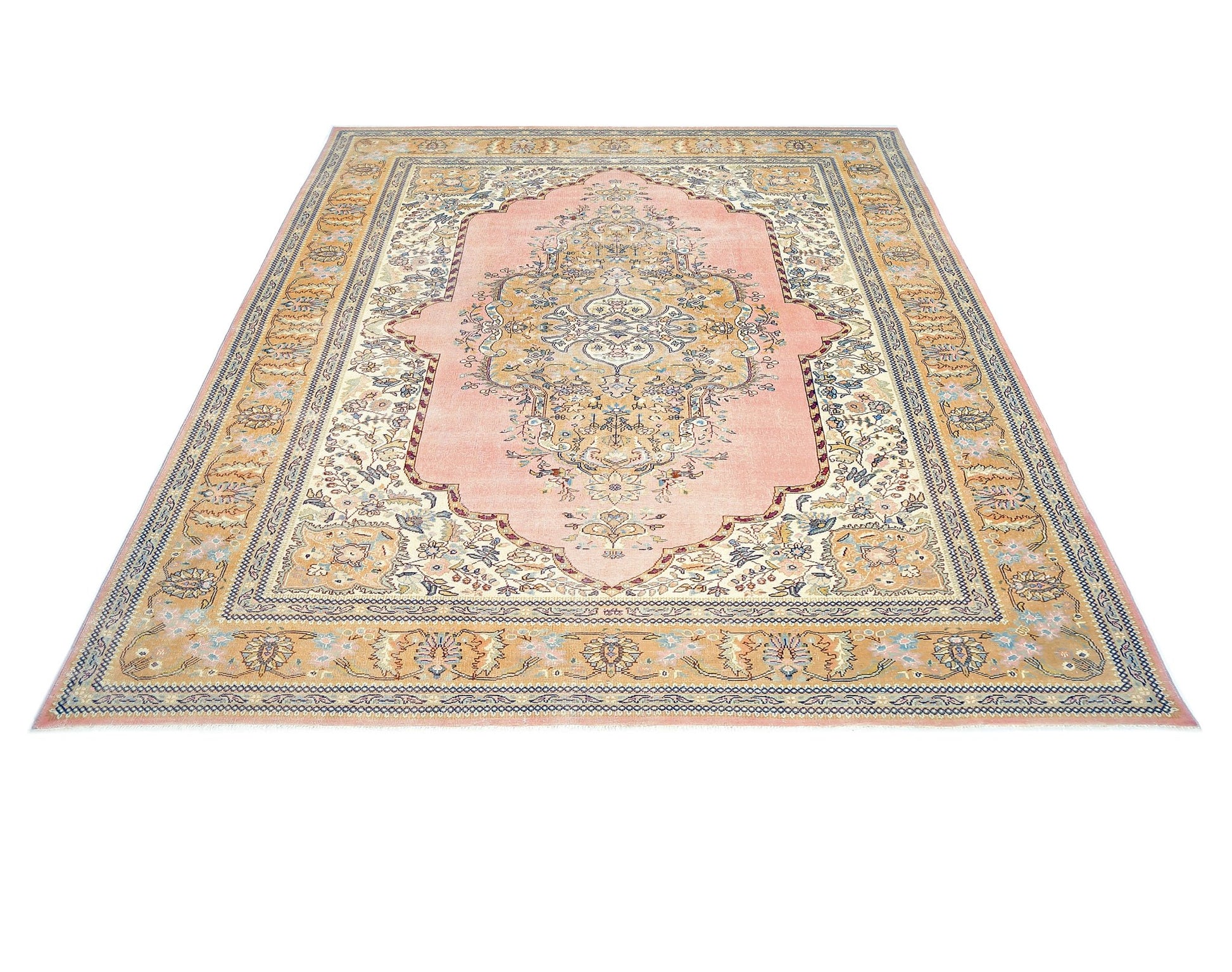 A vintage Persian Tabriz rug featuring an intricate floral medallion on a soft pink field.