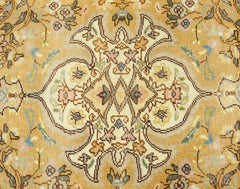 A vintage Persian Tabriz rug featuring an intricate floral medallion pattern in soft gold and cream.