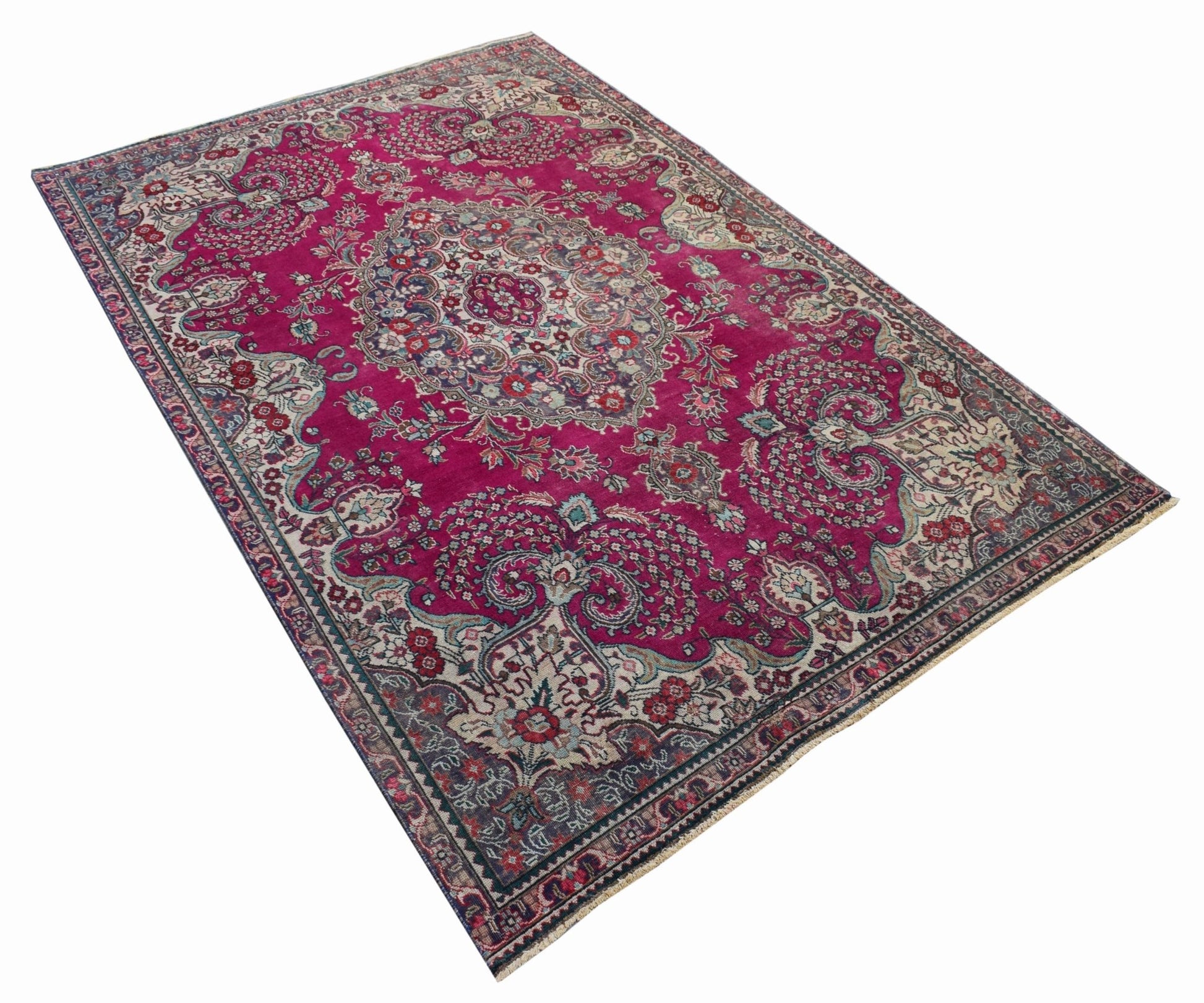 A vintage Persian Tabriz rug featuring an intricate floral medallion on a vibrant magenta field.