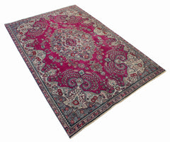 A vintage Persian Tabriz rug featuring an intricate floral medallion on a vibrant magenta field.