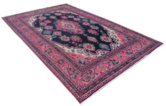 A vintage handmade Persian Tabriz rug featuring a dark blue field with pink floral patterns.