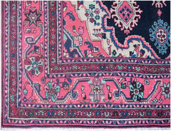 A vintage Persian Tabriz rug featuring a vibrant pink border and a dark blue central medallion.