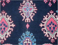 A vintage Persian Tabriz rug featuring a dark blue field with repeating pink and blue geometric motifs.