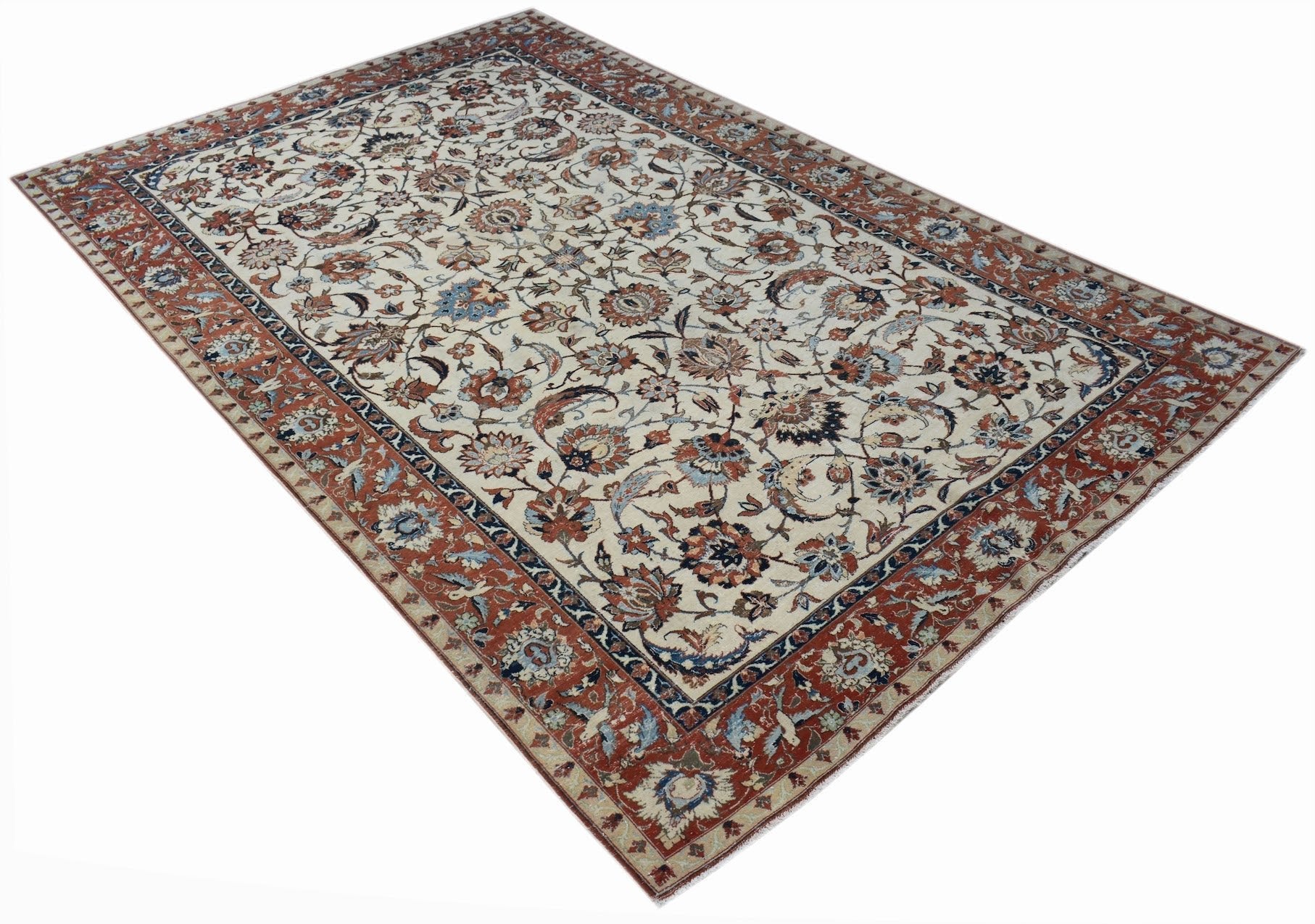 A vintage Persian Kashan rug featuring intricate floral patterns in red, blue, and cream tones.