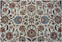 A vintage Persian Kashan rug featuring intricate floral patterns in blue, orange, and cream tones.