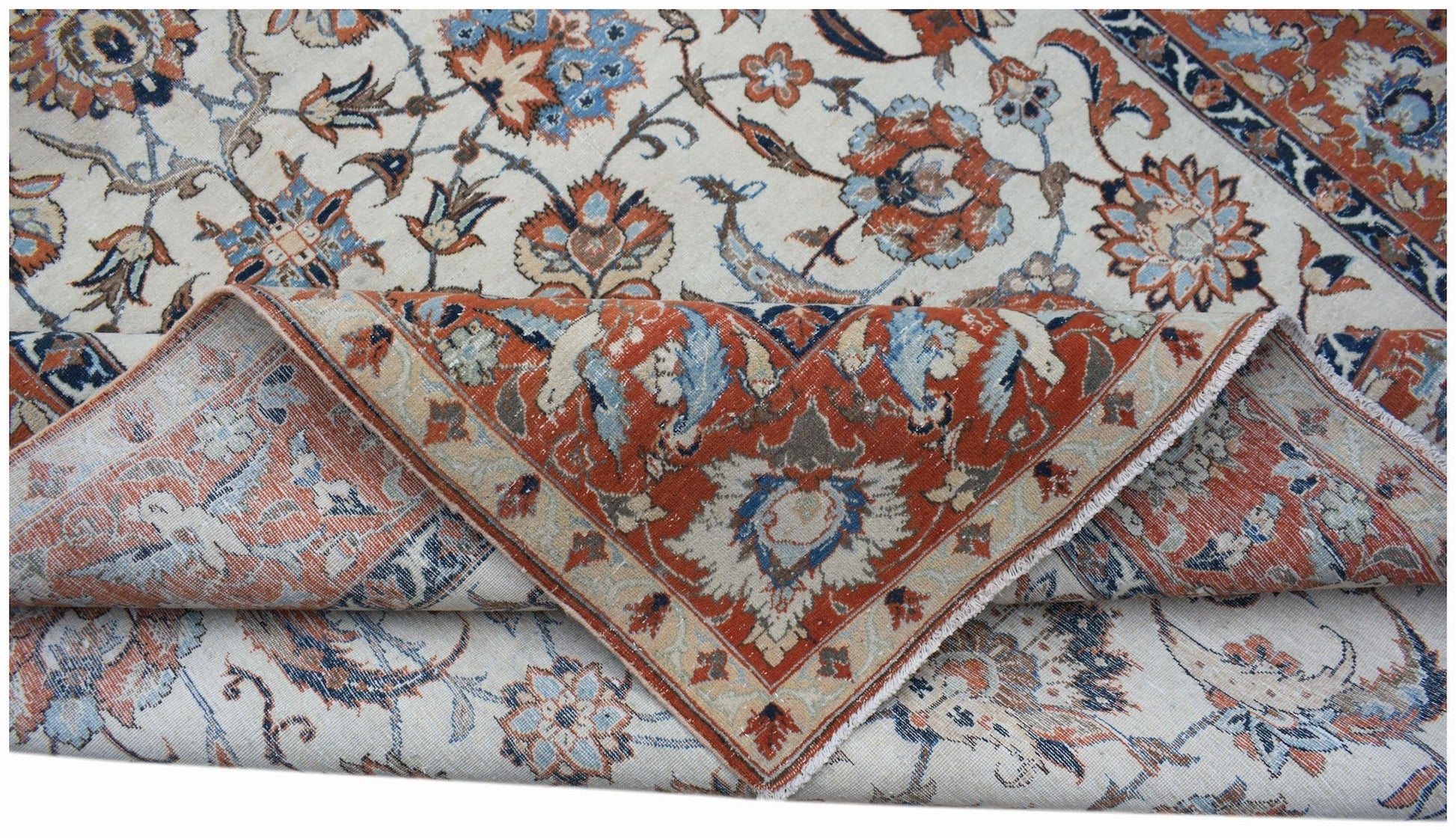 A vintage handwoven Persian Kashan rug featuring intricate floral patterns in rust and blue tones.
