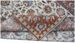 A vintage handwoven Persian Kashan rug featuring intricate floral patterns in rust and blue tones.