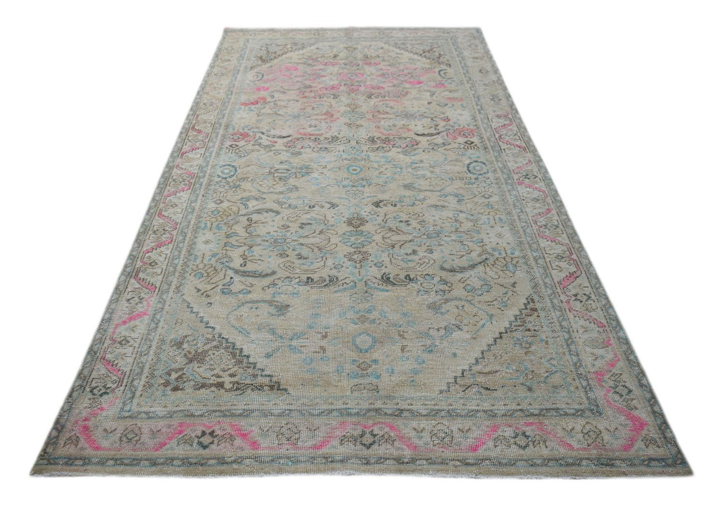 A vintage Persian Tabriz rug featuring a faded floral pattern in pink, blue, and beige tones.