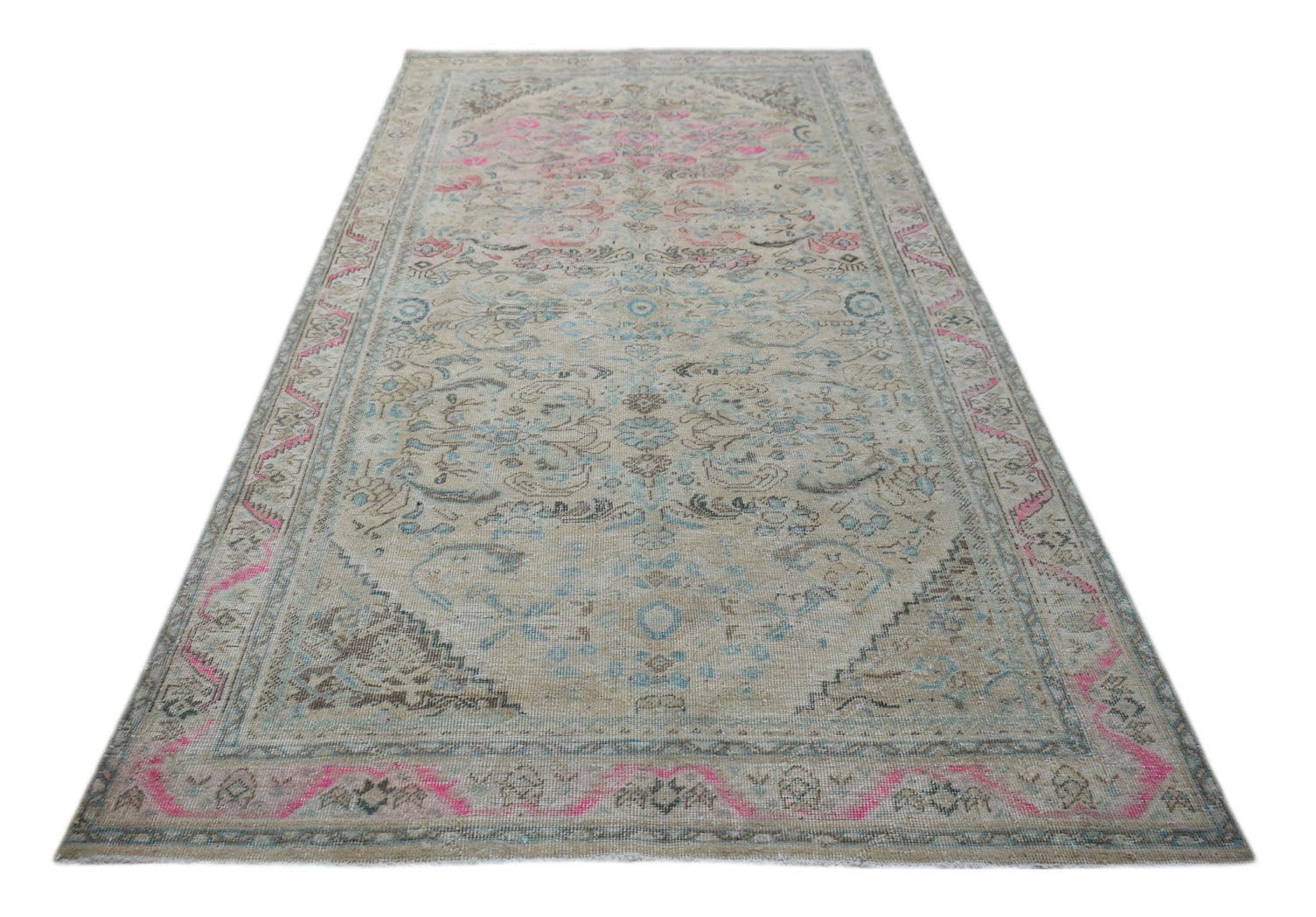 A vintage Persian Tabriz rug featuring a faded floral pattern in pink, blue, and beige tones.