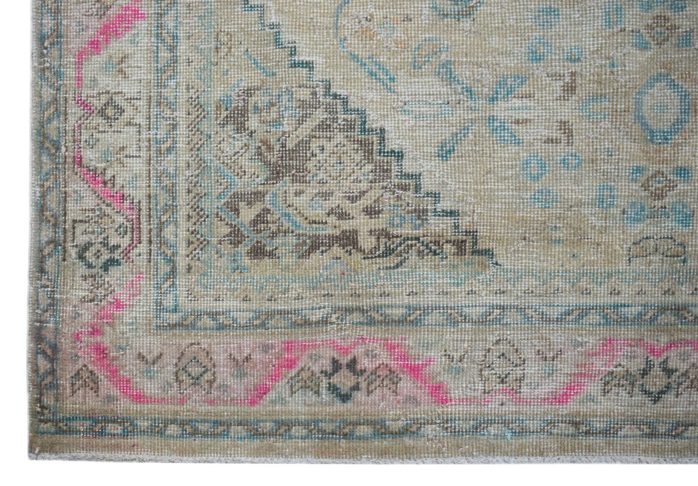 A vintage Persian Tabriz rug featuring a faded beige field with pink and blue geometric patterns.