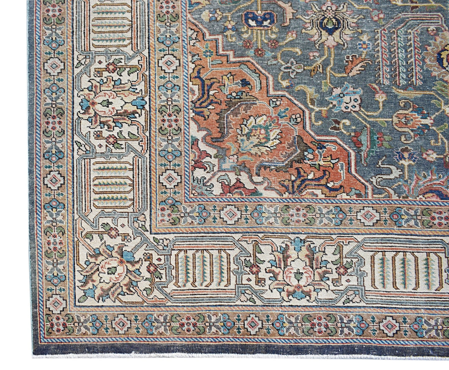 A vintage handwoven Persian Tabriz rug featuring intricate floral patterns in blue and rust tones.
