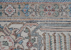 A close-up view of a vintage handwoven Persian Tabriz rug featuring intricate floral patterns.