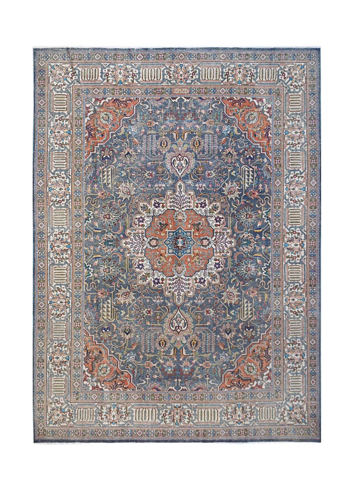 A vintage handwoven Persian Tabriz rug featuring a central floral medallion on a blue field.