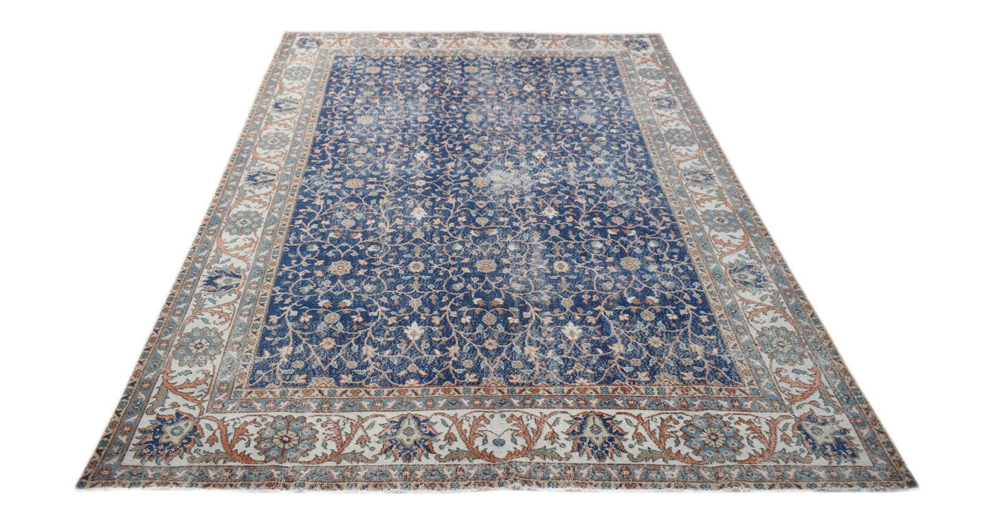 A vintage Persian Tabriz rug featuring a blue field with intricate floral patterns and a wide border.