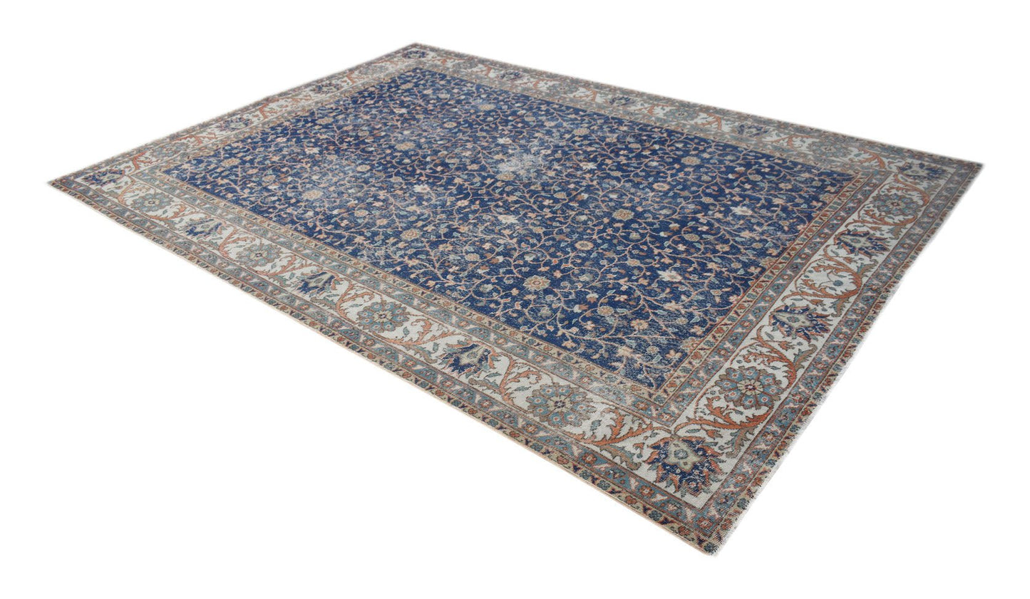 A vintage Persian Tabriz rug featuring a blue field with intricate floral patterns and a wide border.