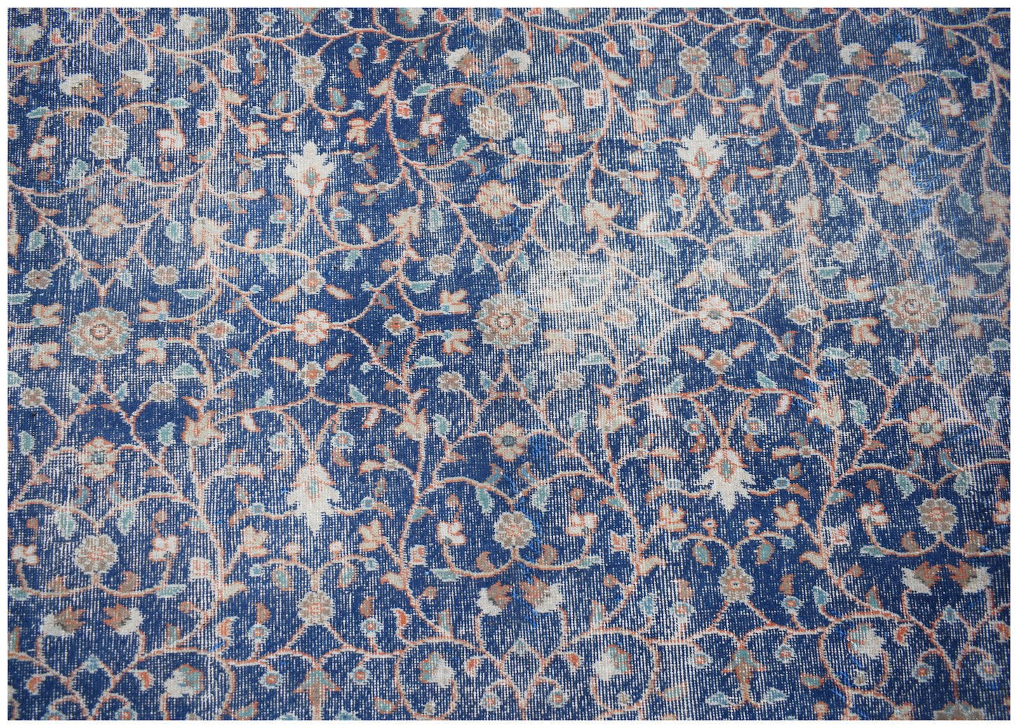 A vintage Persian Tabriz rug featuring an intricate floral pattern in shades of blue and cream.