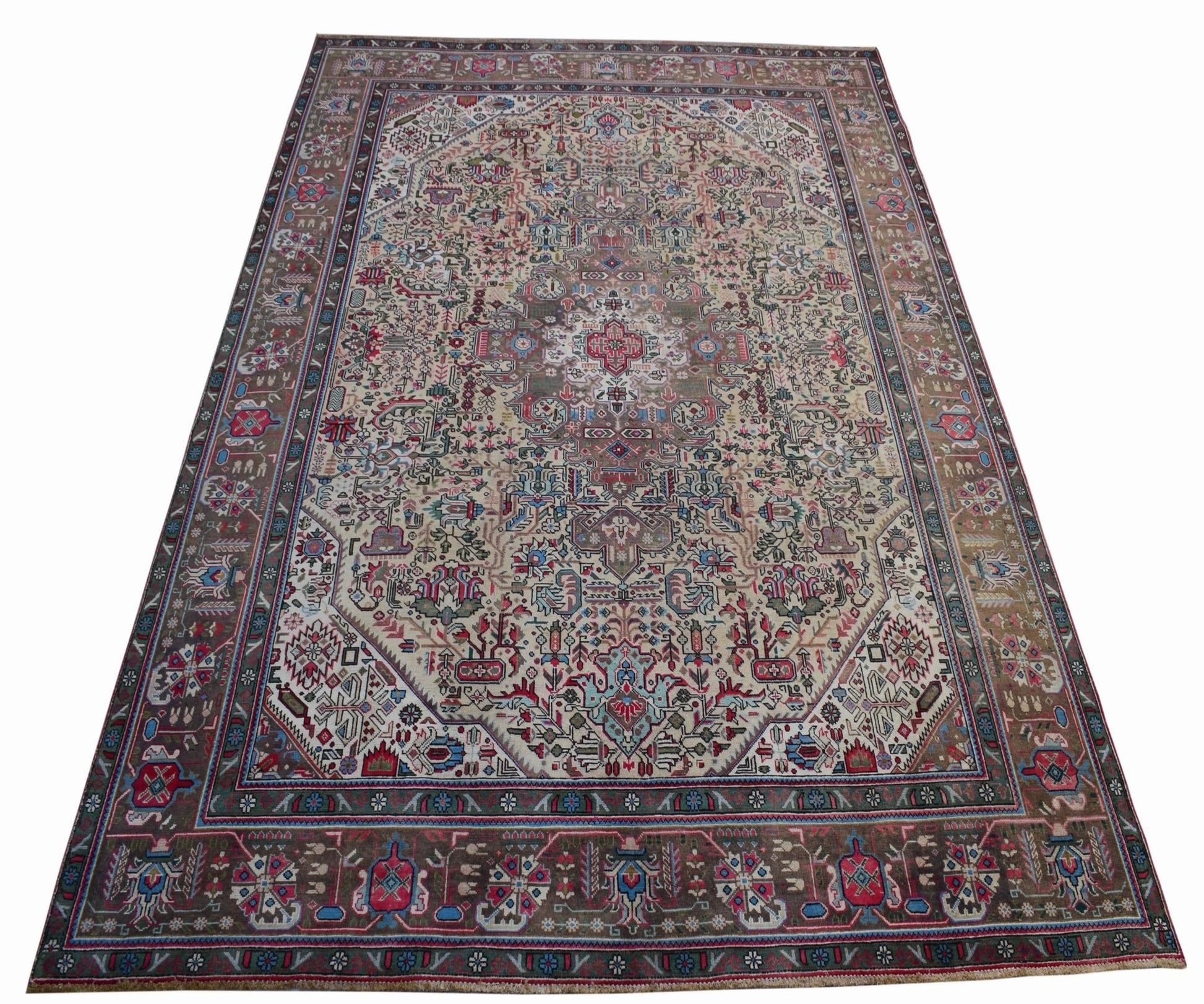 A vintage handwoven Persian Tabriz rug featuring intricate floral patterns in a neutral palette.