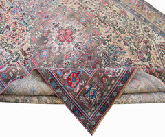 A vintage handwoven Persian Tabriz rug featuring intricate floral patterns in a muted color palette.