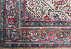 A vintage handwoven Persian Tabriz rug featuring intricate floral patterns in a rich color palette.
