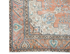 A vintage Persian Tabriz rug featuring intricate floral patterns in shades of orange and blue.