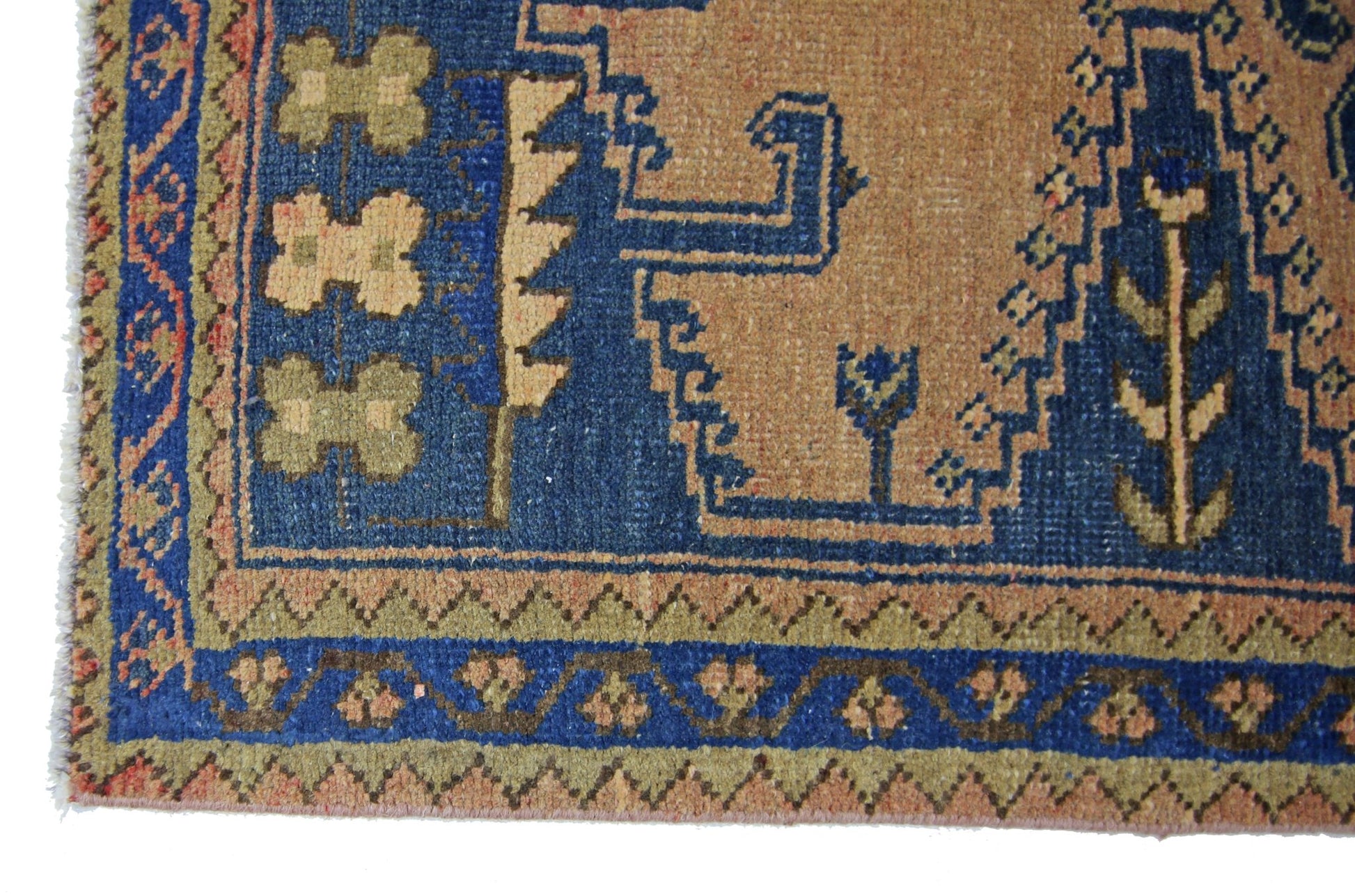 A vintage Persian Wiss rug featuring geometric patterns in blue, tan, and olive wool.