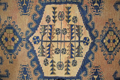 A vintage Persian Wiss rug featuring a central geometric medallion with floral and tree motifs.