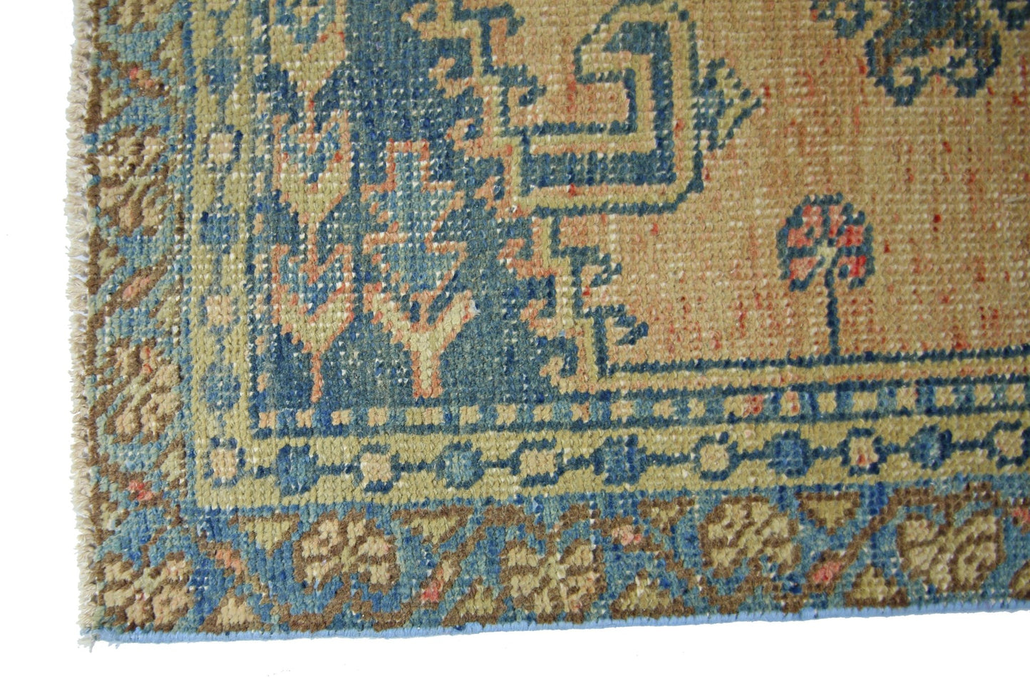 A vintage Persian Wiss rug featuring a geometric blue and tan pattern with a fringed edge.