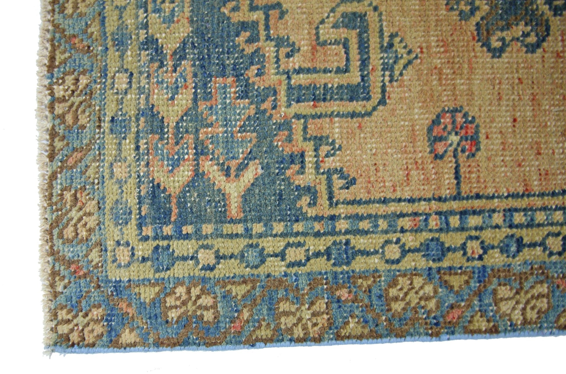 A vintage Persian Wiss rug featuring a geometric blue and tan pattern with a fringed edge.