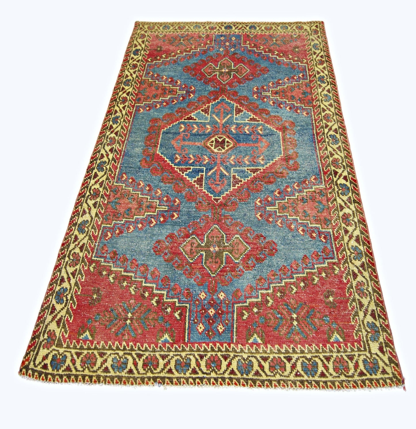 A vintage handmade Persian Wiss rug featuring a geometric red and blue pattern on a wool pile.