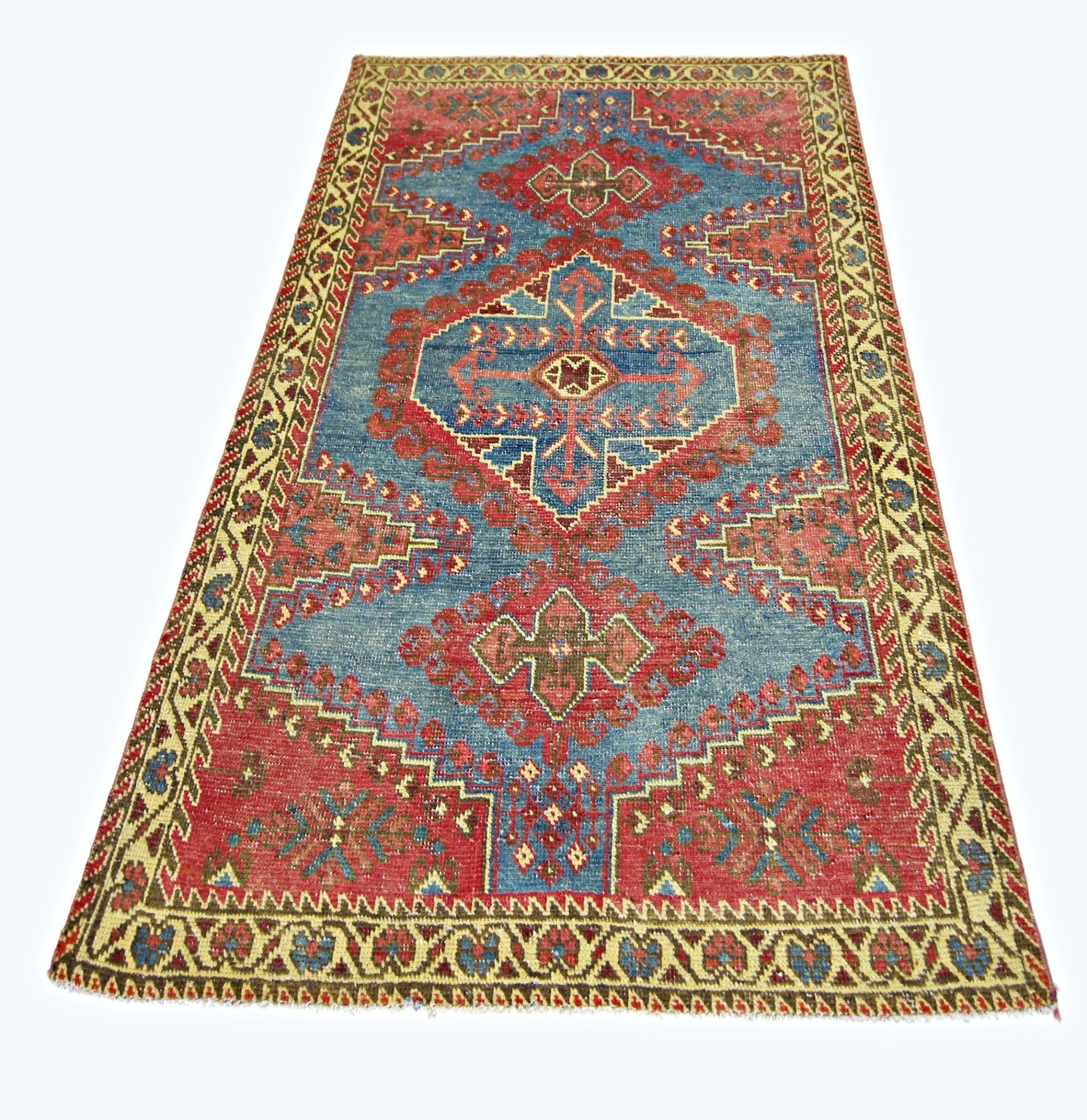 A vintage handmade Persian Wiss rug featuring a geometric red and blue pattern on a wool pile.