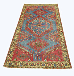 A vintage handmade Persian Wiss rug featuring a geometric red and blue pattern on a wool pile.
