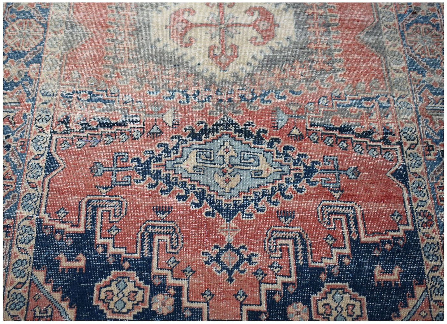 A vintage handwoven Persian Wiss rug featuring a geometric medallion pattern in red and blue.