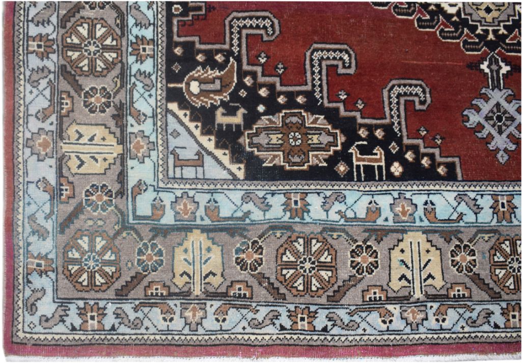 A vintage Persian Wiss rug featuring a geometric red field with blue and grey floral borders.