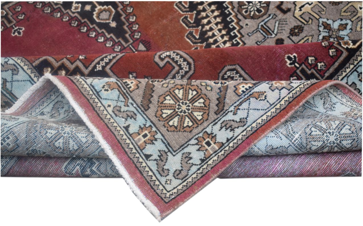 A vintage handmade Persian Wiss wool rug featuring intricate geometric patterns in red and blue.
