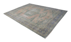 A vintage Persian rug featuring a central medallion and floral patterns in muted pink and blue.
