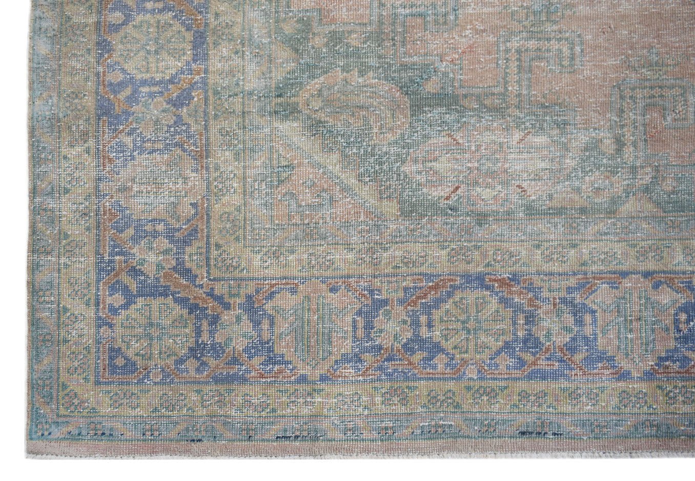 A vintage Persian Wiss rug featuring a faded floral medallion pattern in blue, green, and peach.