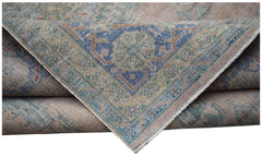 A folded vintage Persian Wiss rug featuring a blue central medallion and intricate floral patterns.