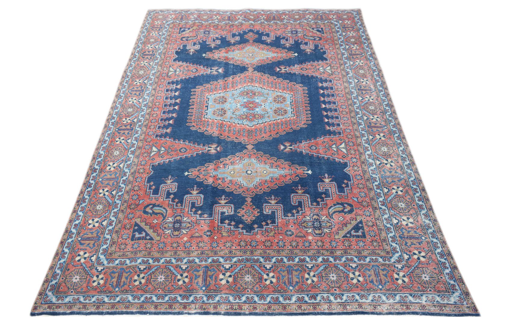 A vintage Persian Wiss rug featuring a blue field with intricate red and light blue geometric motifs.