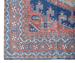 A vintage handwoven Persian Wiss rug featuring a geometric pattern in blue, red, and cream tones.