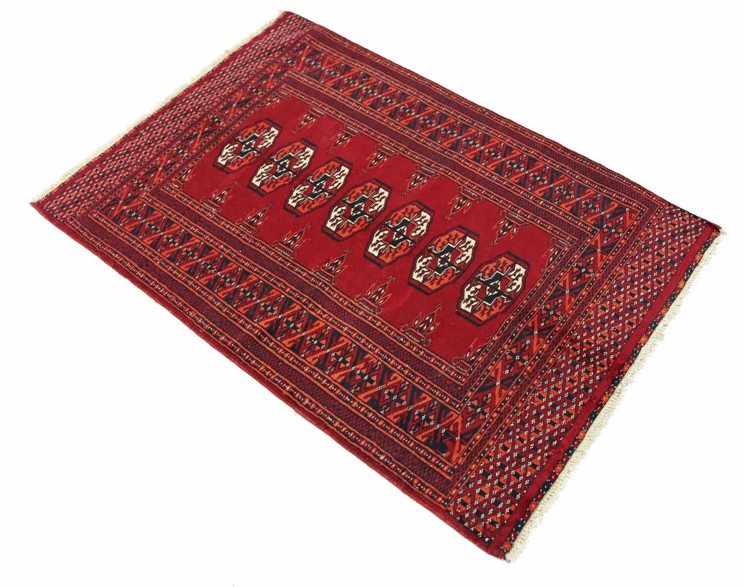 A vintage Pakistani Princess Bokhara rug featuring a red field with repeating geometric motifs.