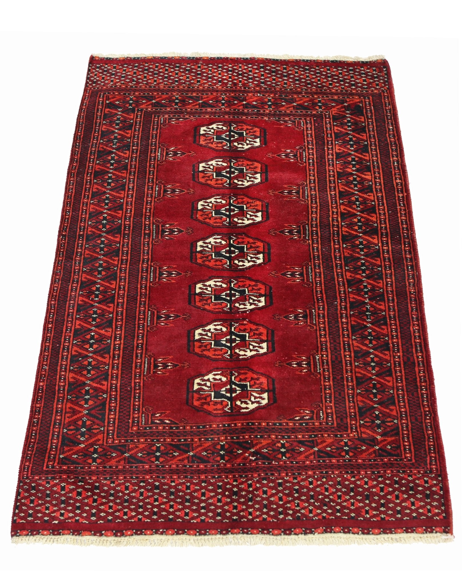 A vintage Pakistani Princess Bokhara rug featuring a deep red field with repeating geometric motifs.