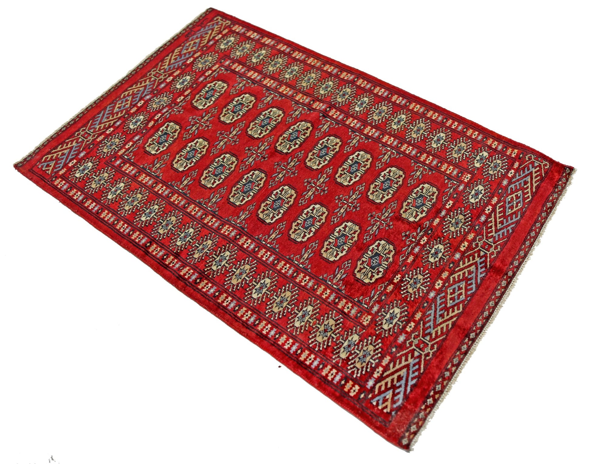 A vintage Pakistani Princess Bokhara rug featuring a repeating geometric pattern on a red field.