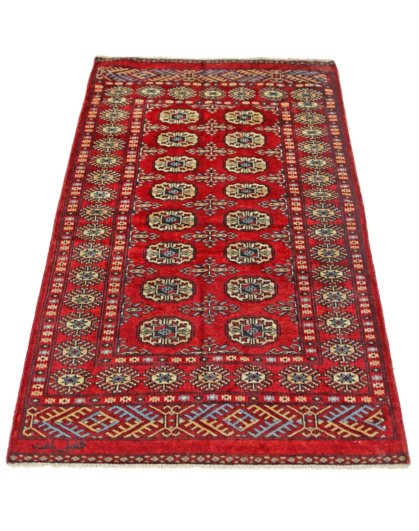 A vintage Pakistani Princess Bokhara rug featuring a repeating geometric pattern on a red field.